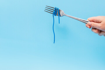 wires wound around a fork on a blue background