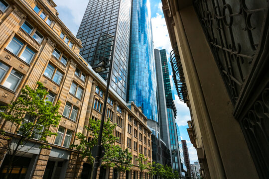 Maintower and Omniturm skyscrapers rise up behind historical buildings facades at Neue Mainzer Stra&szlig;e in Bankenviertel ("banks district"), Frankfurt am Main, Hesse, Germany. 