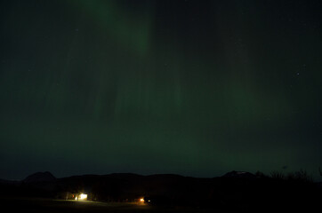 aurora borealis on autumn night sky over houses