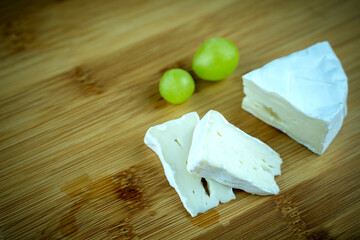 fresh cheese with grapes on a wooden background