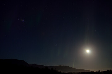 Fototapeta na wymiar full moon, aurora borealis and clouds
