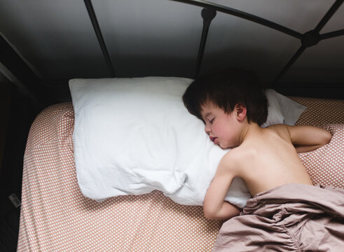 little boy sleeping in bed