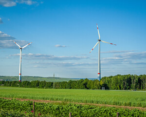 Windräder auf einem grünen Feld in der Landschaft 