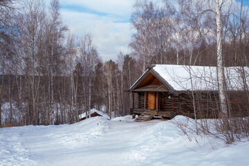 Fototapeta na wymiar Wooden old house in the forest in snowy winter.