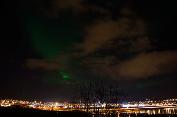 beautiful aurora borealis over the arctic city of tromsoe on a late autumn night