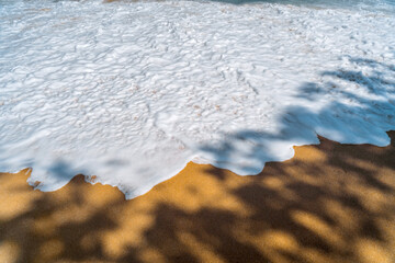 Sea foam on the sand of a tropical beach. Exotic background. Beach holiday. Tourist destination Thailand