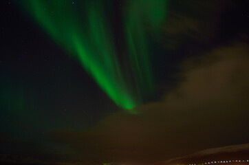 Vivid green aurora borealis, northern light on late autumn night sky