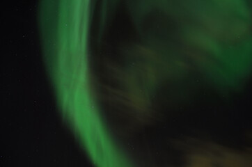 Vivid green aurora borealis, northern light on late autumn night sky