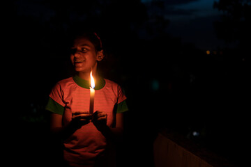 Teenage Indian girl holding enlighten candle