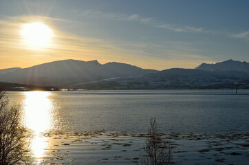 Obraz na płótnie Canvas sun over blue fjord landscape