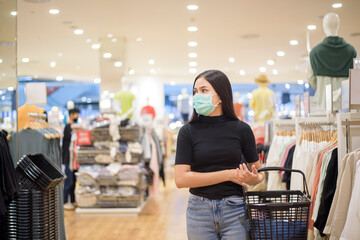 woman with face mask is shopping clothes in Shopping center