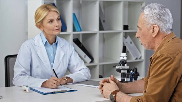 doctor listening patient and writing prescription