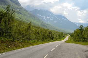 Fototapeta premium long narrow mountain road going through the arctic summer mountain and valley landscape