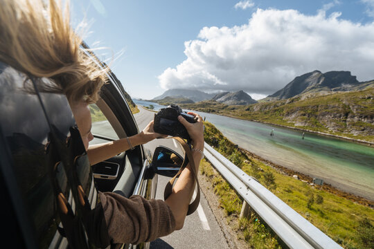 Woman in car taking picture of beautiful nature with camera