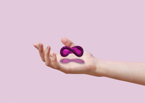 Flying condom above the hand with shadow.