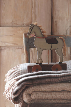 Closeup of toy horse with wool blankets on chair
