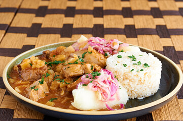 Carapulcra an authentic and traditional Peruvian dish made of dry potatoes, saute with chicken, pork, Peruvian spices and red dried hot peppers sauce.