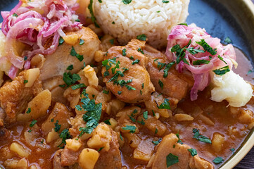 Carapulcra an authentic and traditional Peruvian dish made of dry potatoes, saute with chicken, pork, Peruvian spices and red dried hot peppers sauce.