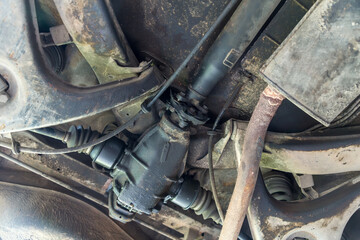 Under old car rear wheel axle  dirty fix repair in garage. Vehicle shaft axle of power transmission to wheel of car
