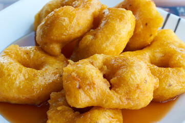 Picarones: These are ring-shaped dessert made ​​with wheat flour dough mixed with pumpkin and sweet potato. fried and dipped in fig molasses. An authentic and traditional dessert of Peruvian cuisine.