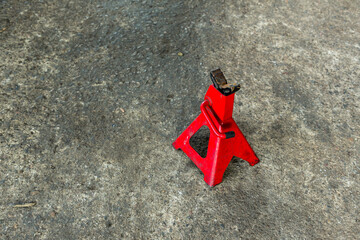 Red axle stand on floor. Red high lift jack stand on the floor. Red extendable jack stands are used...