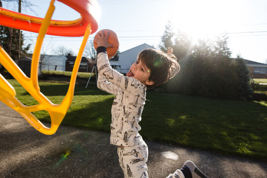 Boy playing basketball in backyard