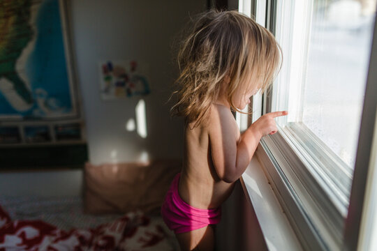 little girl looks out window