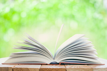 open book on the table in the nature background with bokeh lights