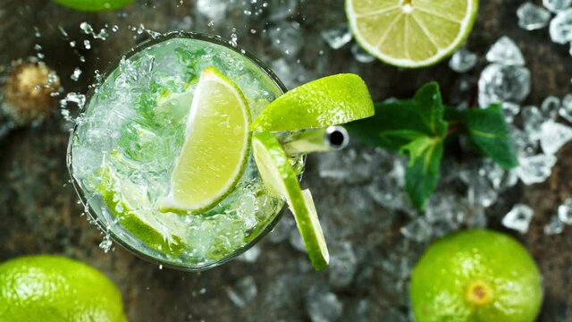 Refreshing mojito cocktail in a glass on black stone table, macro super slow motion filmed on high speed cinematic camera.