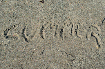 summer written in beach sand