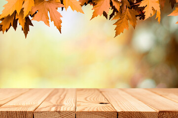 Naklejka na ściany i meble maple leaves with wood table top on the autumn blurred background with bokeh lights