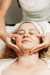 Fototapeta na wymiar Close-up of face massage treatment. Young Caucasian woman. Beauty treatments