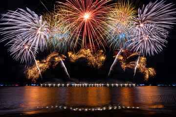 Beautiful colorful firework display over sea on celebration night. Firework festival showing on independence day or happy new year.