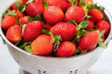 Organic strawberry in metal bowl. Close-up.