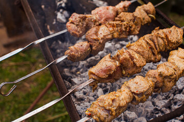Marinated meat on the metal skewers cooked on the grill