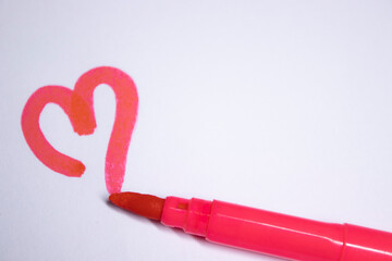 pink felt-tip pen with a painted heart next to it. stationery concept. copy space. isolated. High...