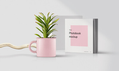 A mug with a green plant on the table. Minimalistic branding. Photo album or book cover mockup. 