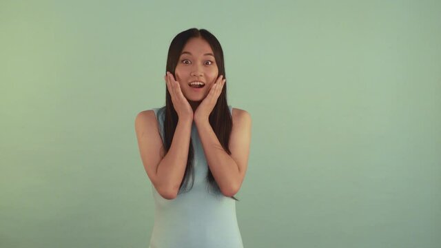 Shock. Portrait midle shoot. Very surprised Asian girl. Girl covers her mouth with hand 4K