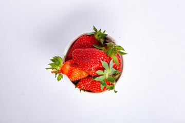 Ripe strawberries close-up. Strawberries in bowl isolated on white background. Sweet and juicy berry with copy space for text. Strawberries on white.