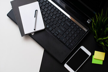 the phone and the laptop on the black and white table