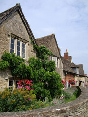 Fototapeta na wymiar A street view with old stone houses in nine hundred years old Lacock village, in Wiltshire, England, UK.