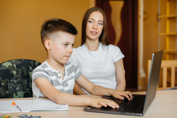 A mother and her child are engaged in distance learning at home in front of the computer. Stay at home, training