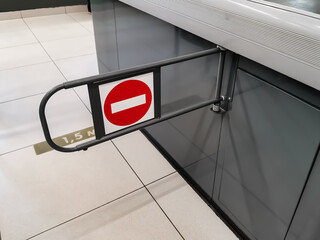 The closed barrier at the checkout counter of the supermarket with the sign 