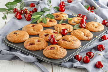 Freshly baked cherry muffins with fresh berries on a rustic wooden table