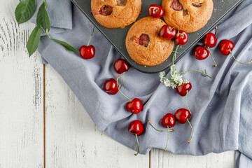 Homemade baking. Cupcakes with cherries.Dessert decorates with fresh berries and leaves. Wooden background. Food styling