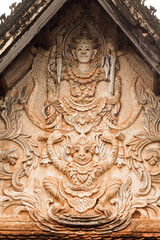 Fototapeta na wymiar Laos. Carving of Hindu God Vishnu and his carrier Garuda the mythical eagle at temple front.