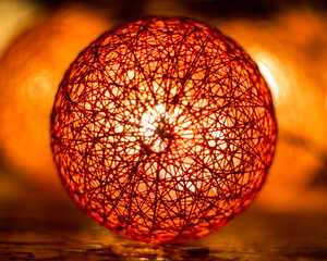 Centered thread ball lamp with other lamps blurred in the background.