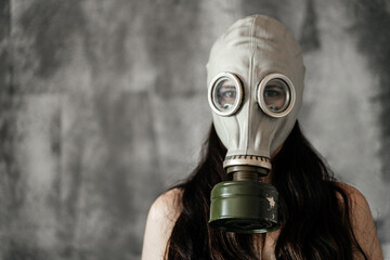 Close-up portrait of a girl in a gas mask on a gray background