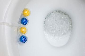 Clean toilet bowl with a cleaning and refreshing balls. Multi-colored balls of toilet bowl cleaner