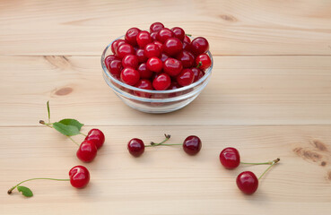 Red cherry on a light wooden table.